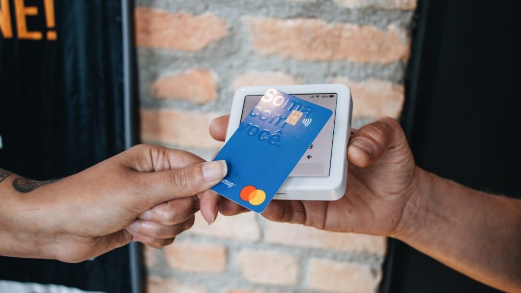 a-person-handing-a-credit-card-to-another-person-5spouxppwtc